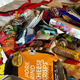 Hotel bed strewn with tons of candy and snack packages